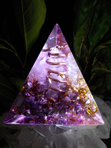 Orgonite pyramide a base triangulaire en quartz rose, cristal de roche, cuivre, aluminium et bronze.  5,8cm.     Apaisant, énergie douce qui apaisera le stress, apporte la confiance, plus d’amour envers soi, une vison avec moins de préjugés sur le monde.  Enseigne l'infinie puissance de l'amour inconditionnel et vous amène vers une vision globale des choses.  Favorise l’entente et la communication sans conflit.  Aide à dormir grâce à son énergie rassurante.  Apporte l’amour et le sentiment de sécurité, la c