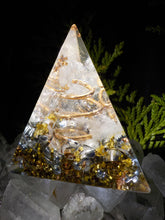 Orgonite pyramide à base triangulaire en cristal de roche, cuivre, bronze et feuilles dorées.