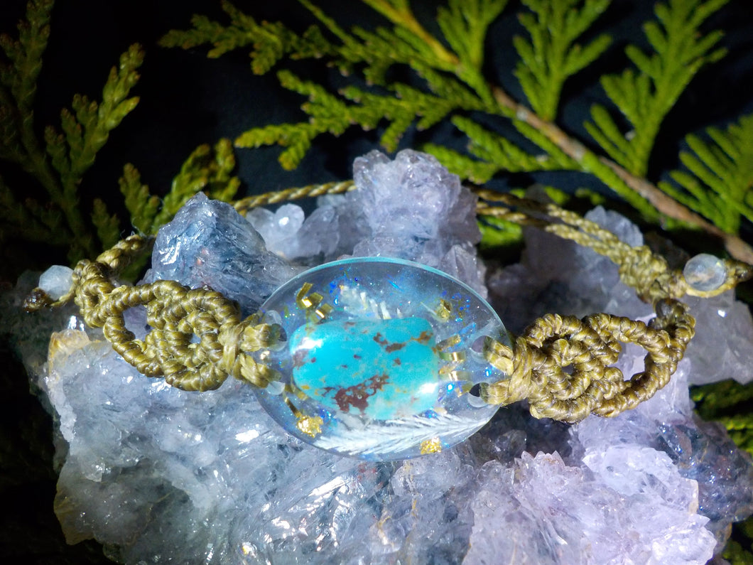 Orgonite en turquoise, cristal de roche, bronze, feuilles dorées et argentées, végétal et perles de labradorite.  2.4 x 1.8 cm.  bracelet réglable en fil polyester.  Pierre dite de 